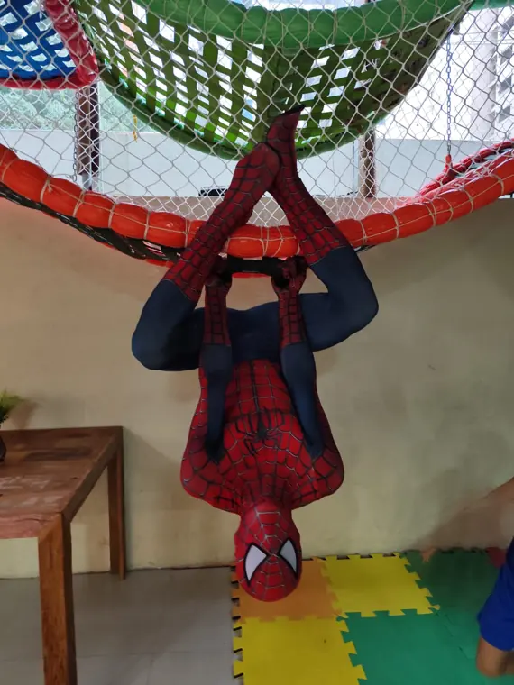 Homem-Aranha pendurado de cabeça para baixo em festa