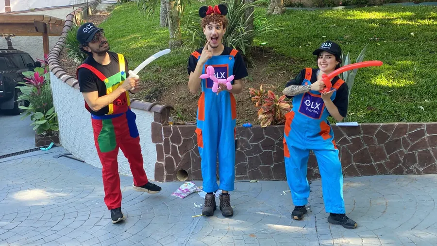 Equipe de recreação da GLX uniformizada com esculturas de bexiga